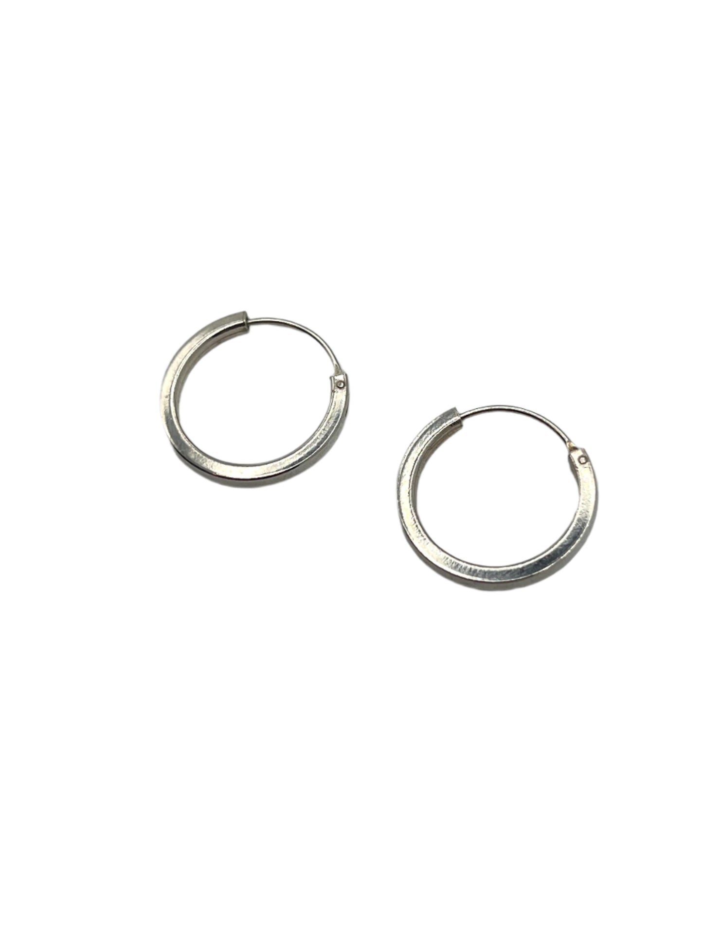Pair of silver hoop earrings on a gray background