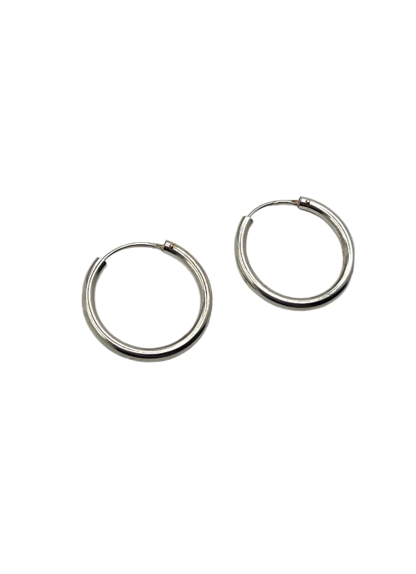 Pair of silver hoop earrings on a light gray background