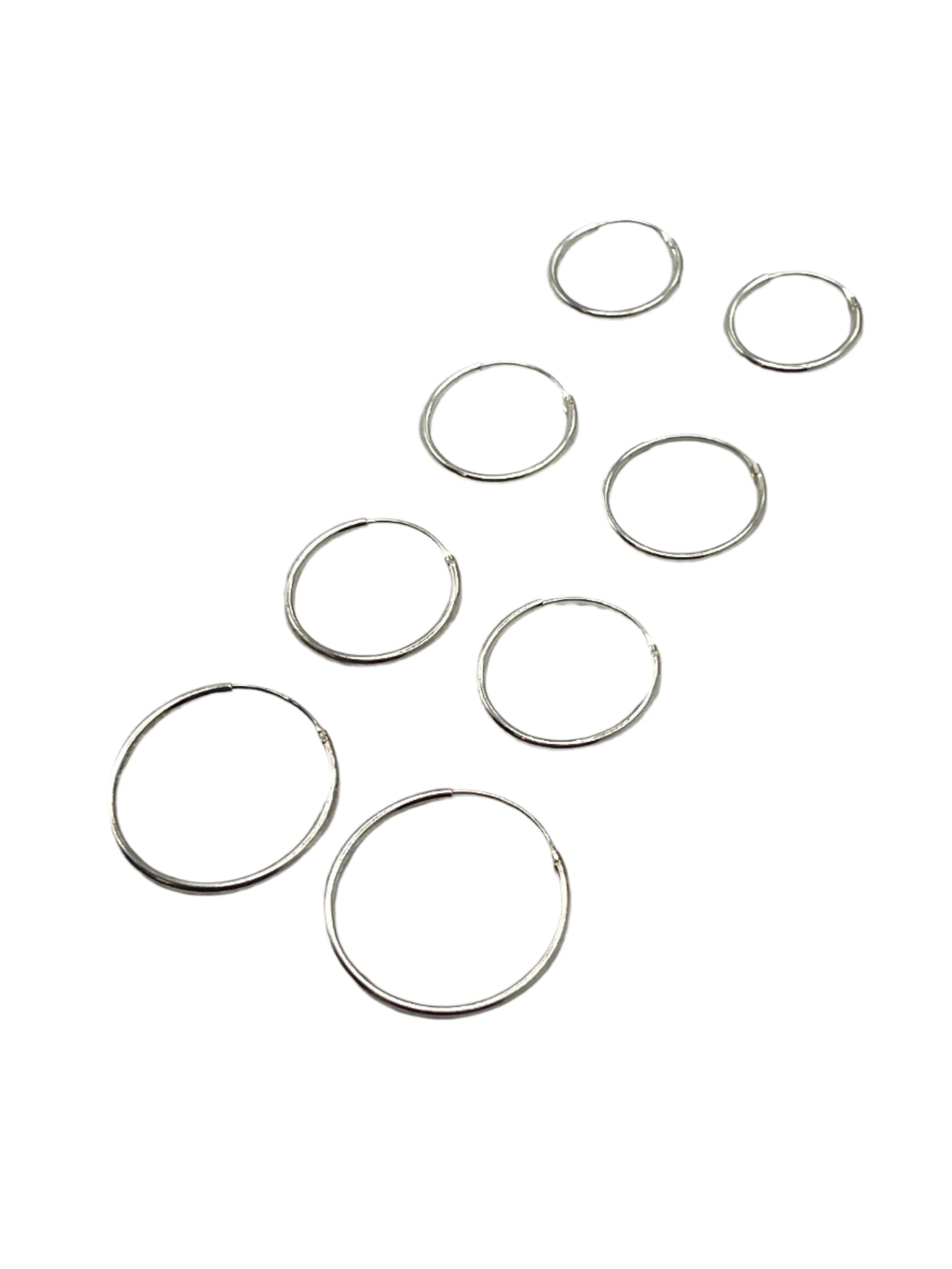 Set of silver hoop earrings on a gray background