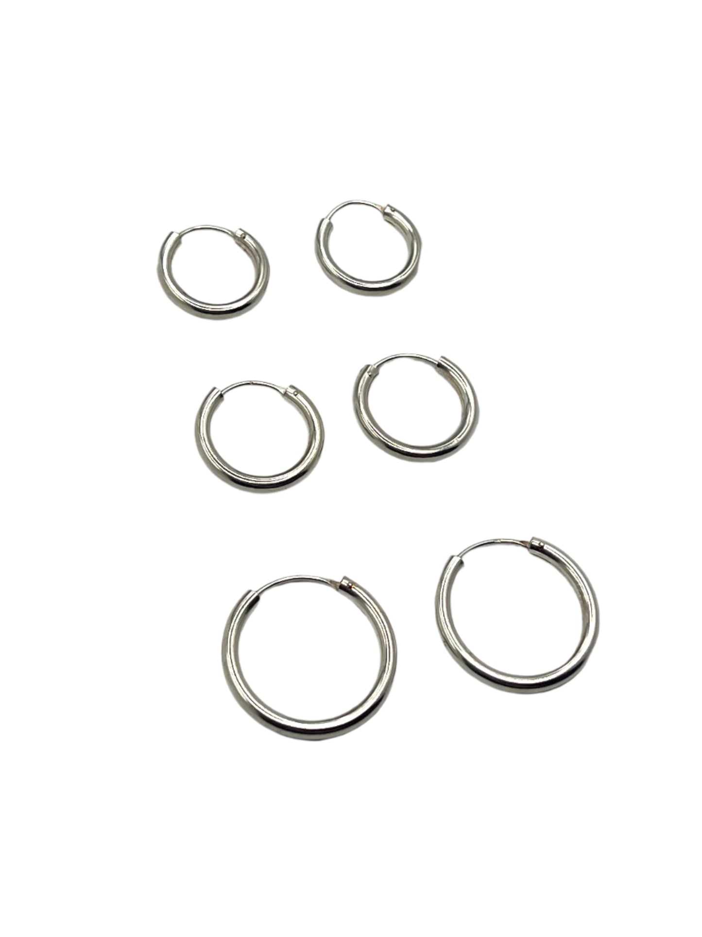 Set of six silver hoop earrings on a light gray background