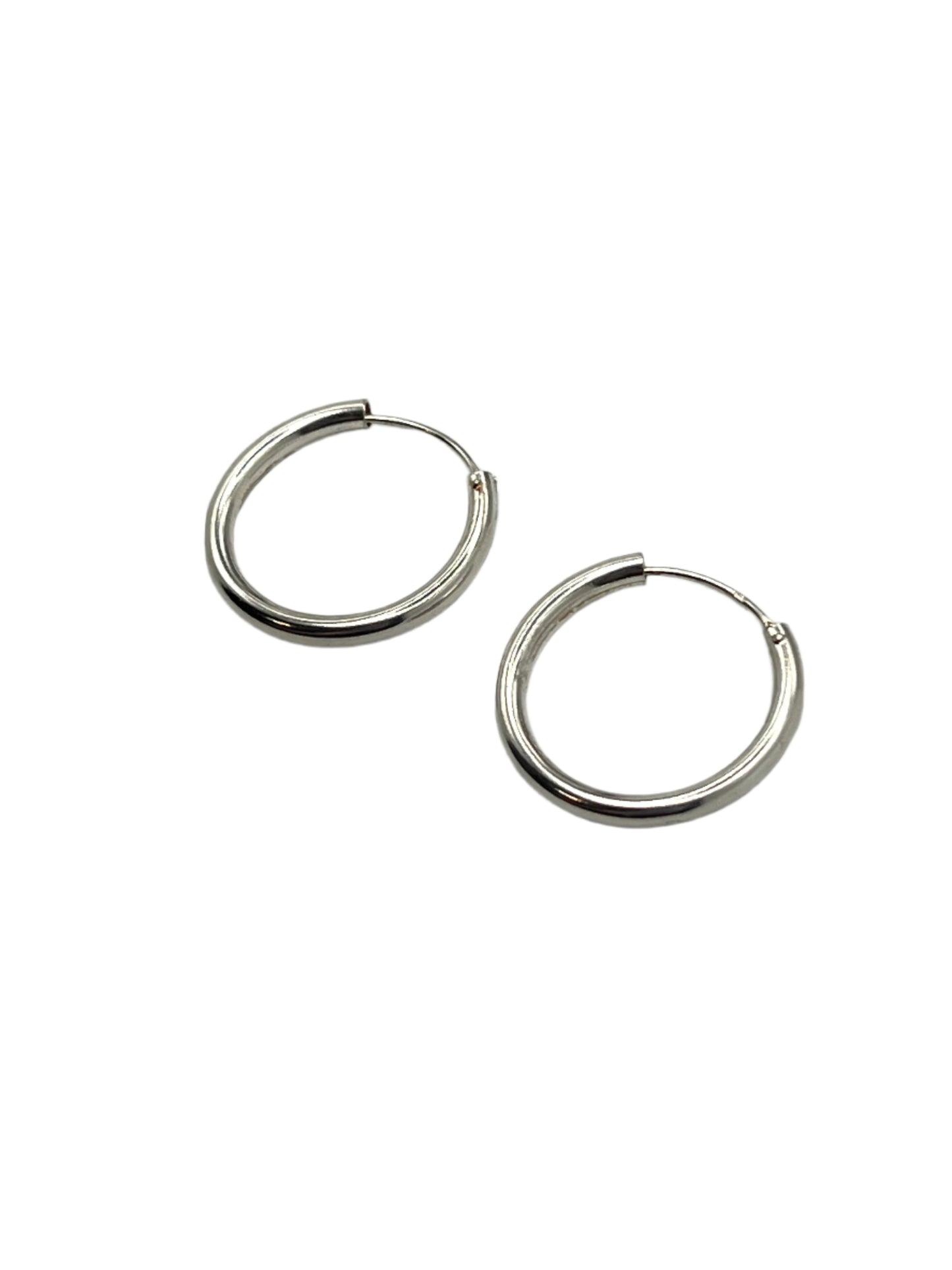 Pair of silver hoop earrings on a light gray background