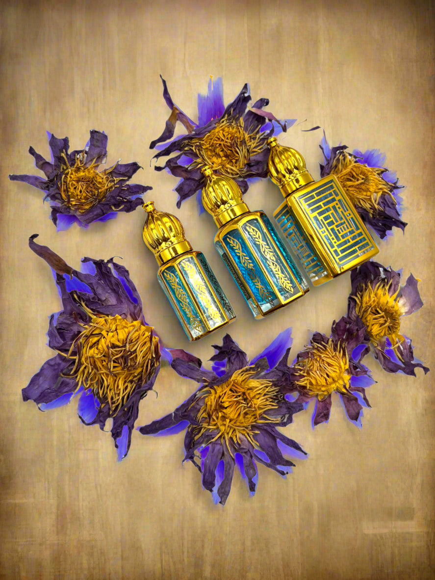 Three small decorative bottles with gold and blue accents on a white background surrounded by purple and yellow flowers.