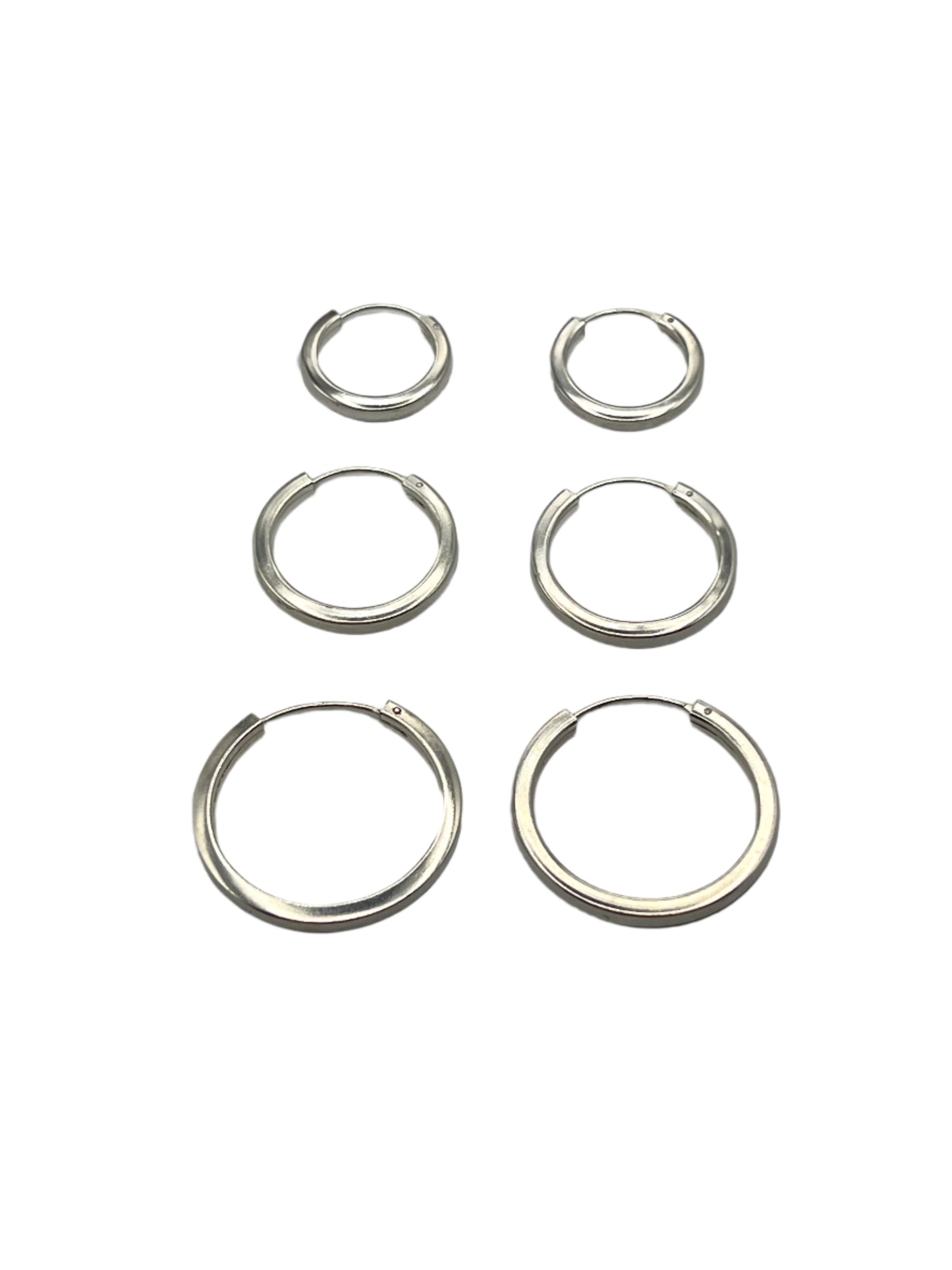 Set of six silver hoop earrings on a gray background