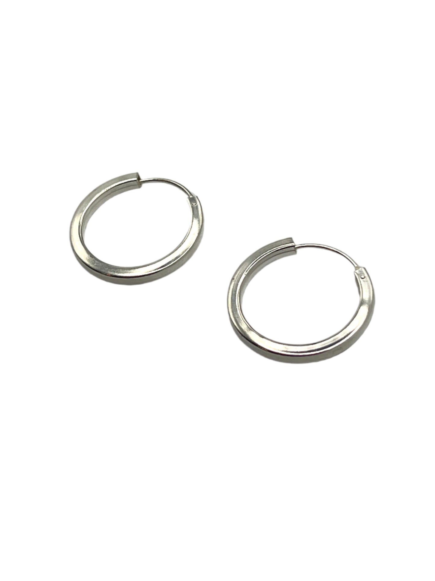 Pair of silver hoop earrings on a gray background