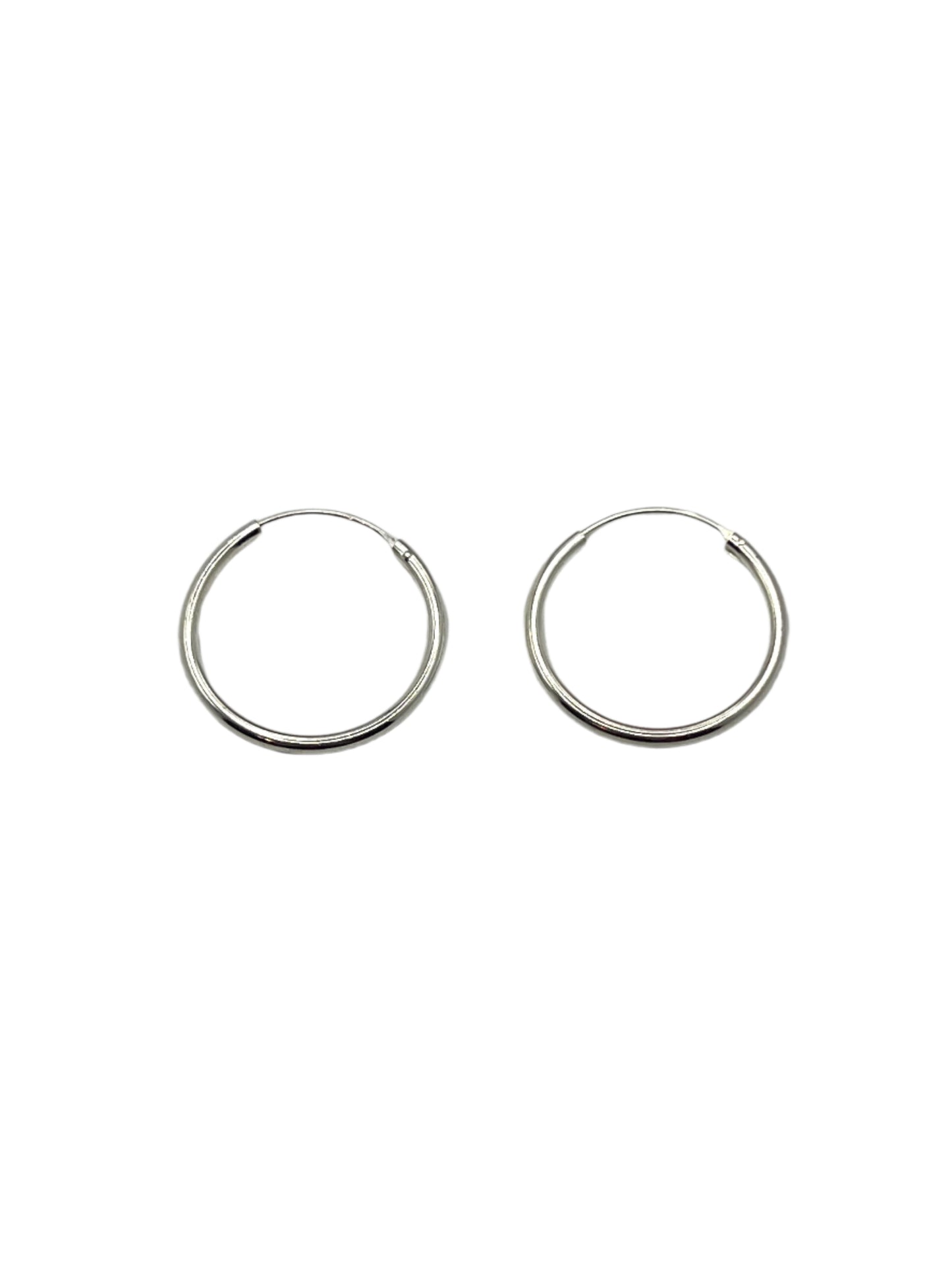 Two silver hoop earrings on a light gray background