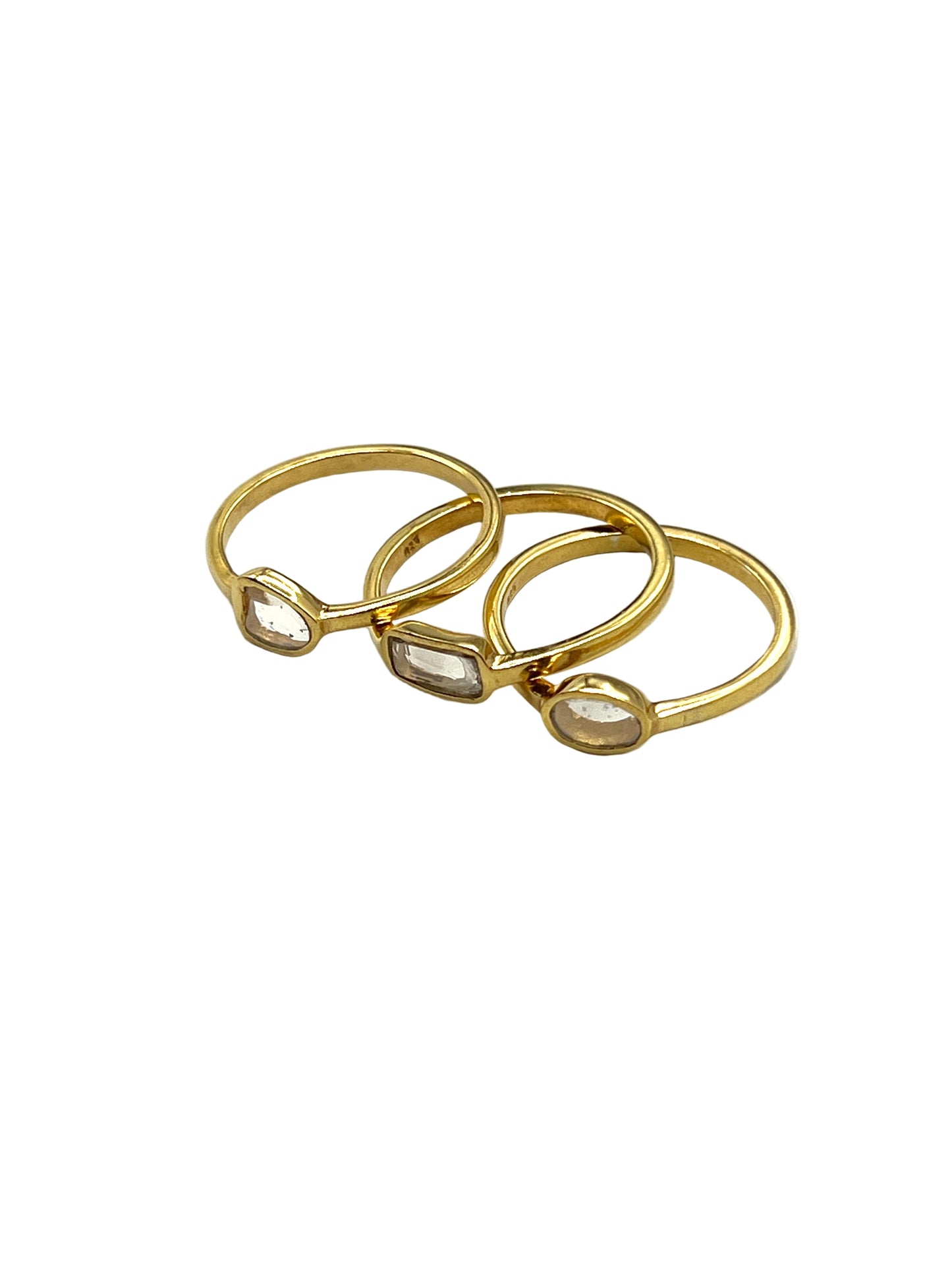 Three gold rings stacked on a white background