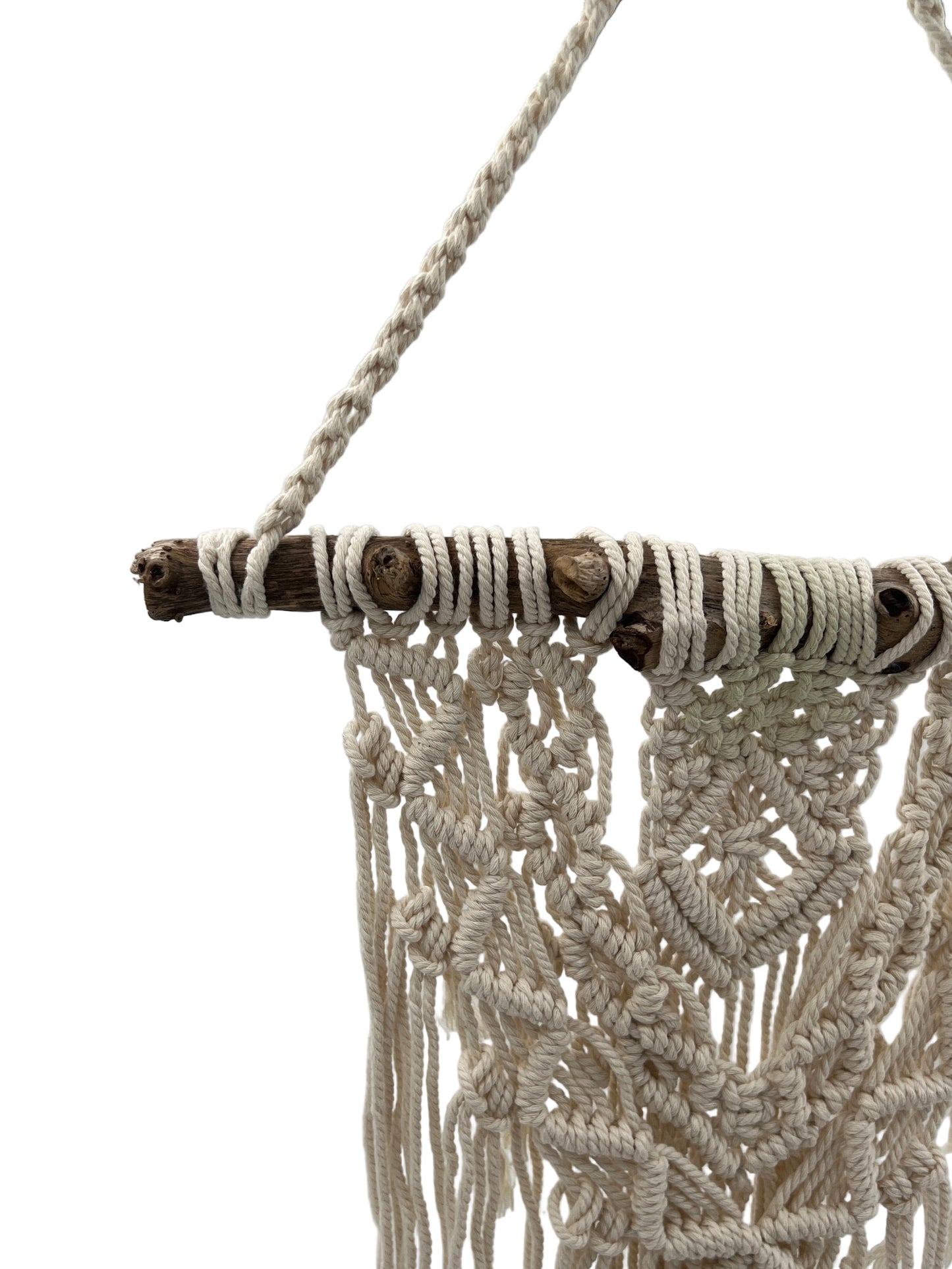 Macrame wall hanging with wooden dowel on a plain background