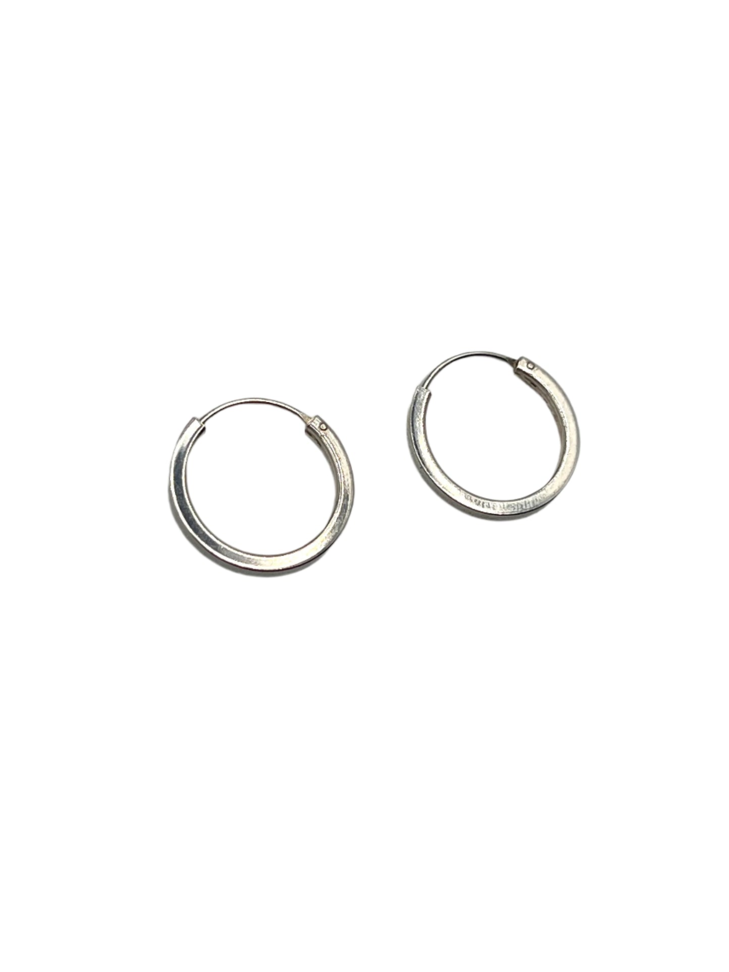 Pair of silver hoop earrings on a gray background