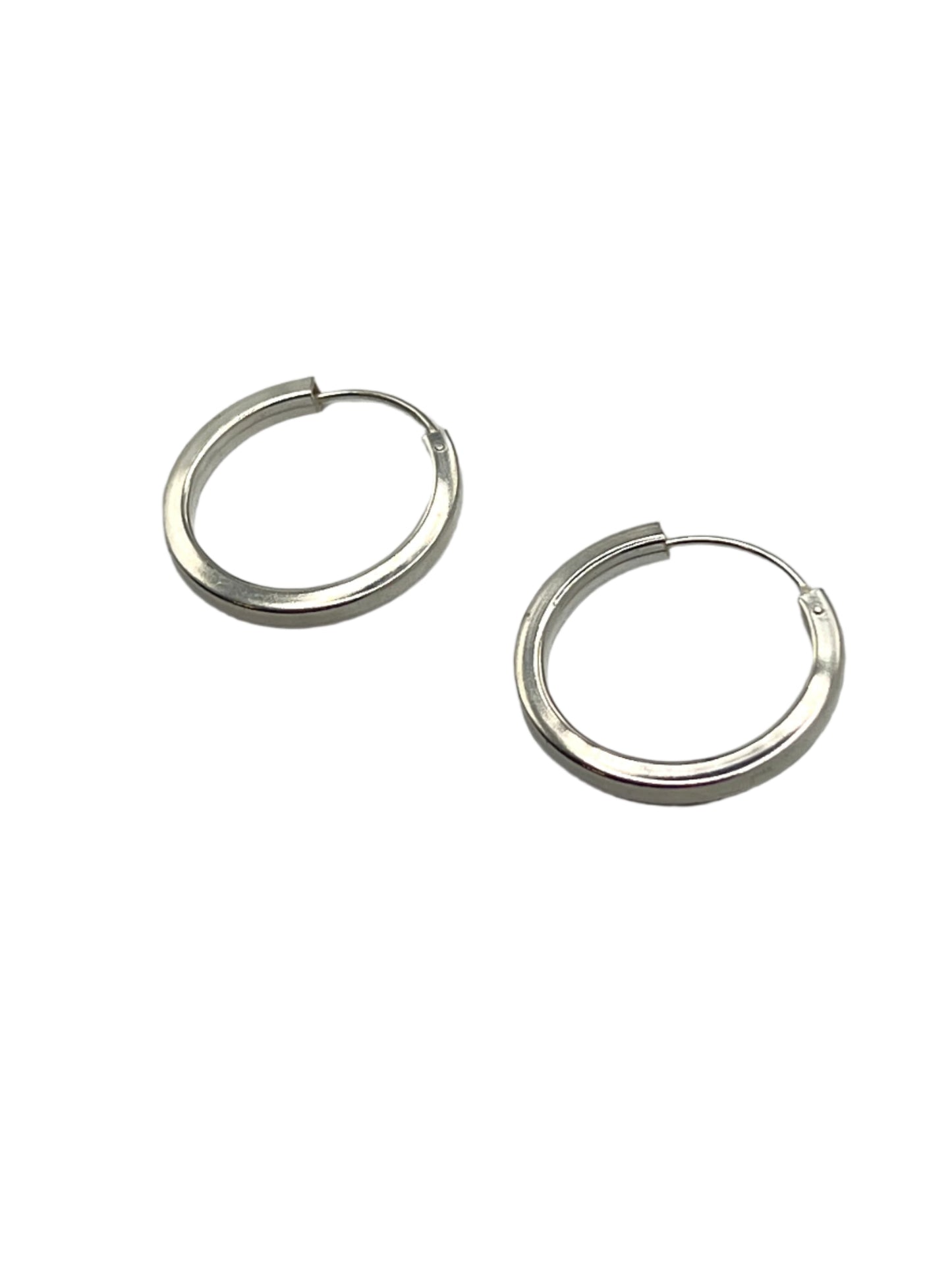 Pair of silver hoop earrings on a gray background