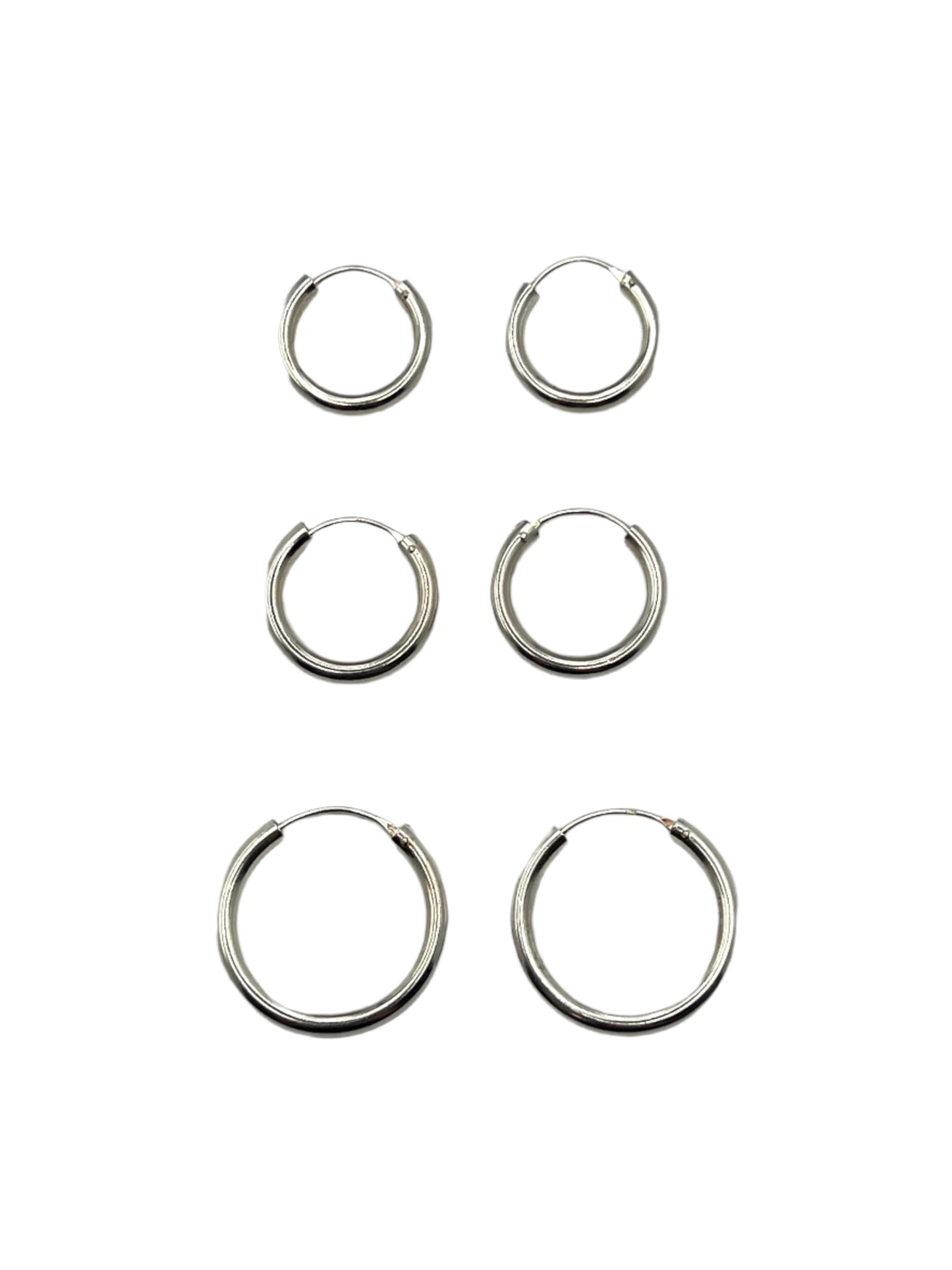 Set of six silver hoop earrings on a gray background