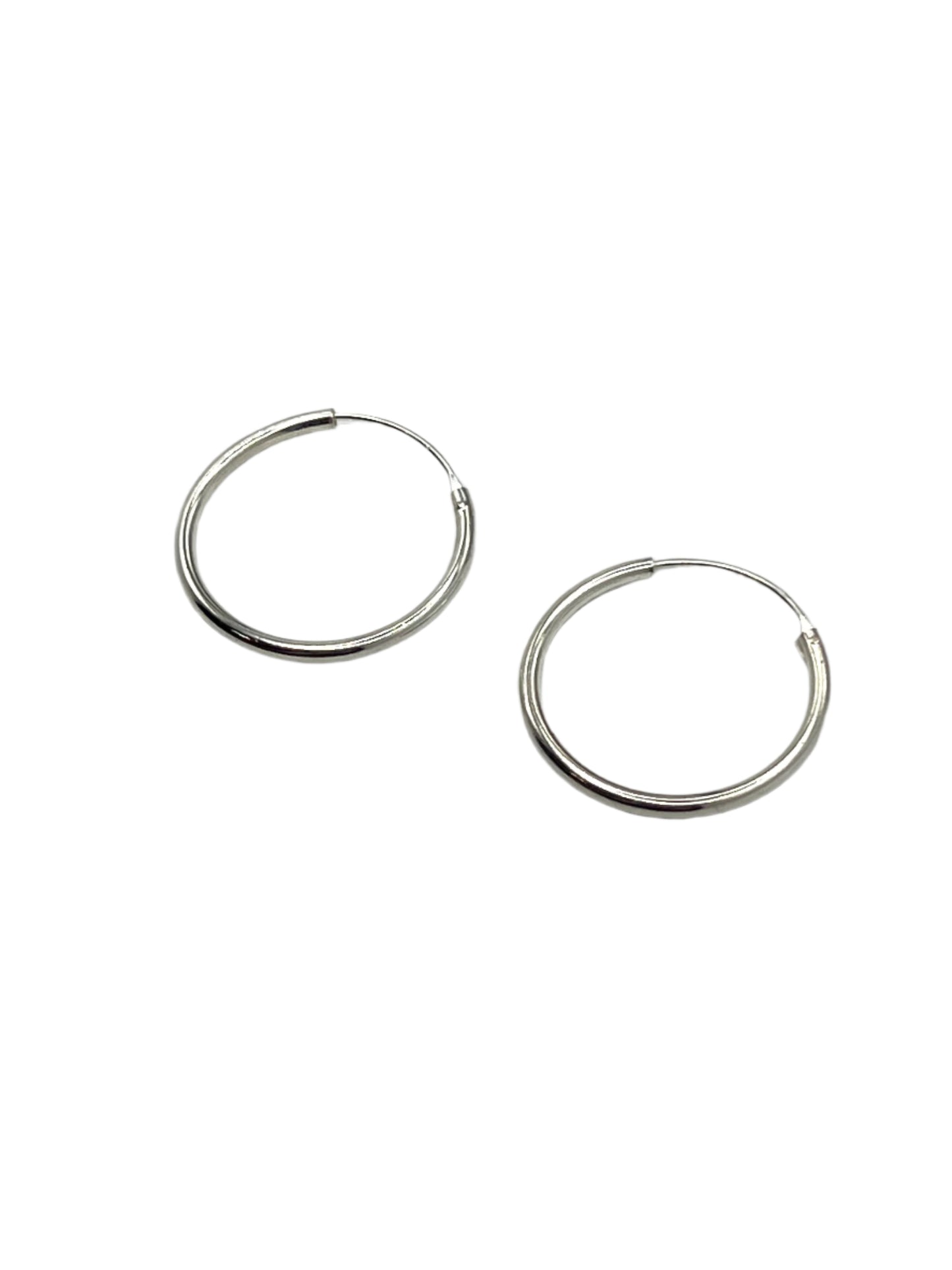 Pair of silver hoop earrings on a light gray background