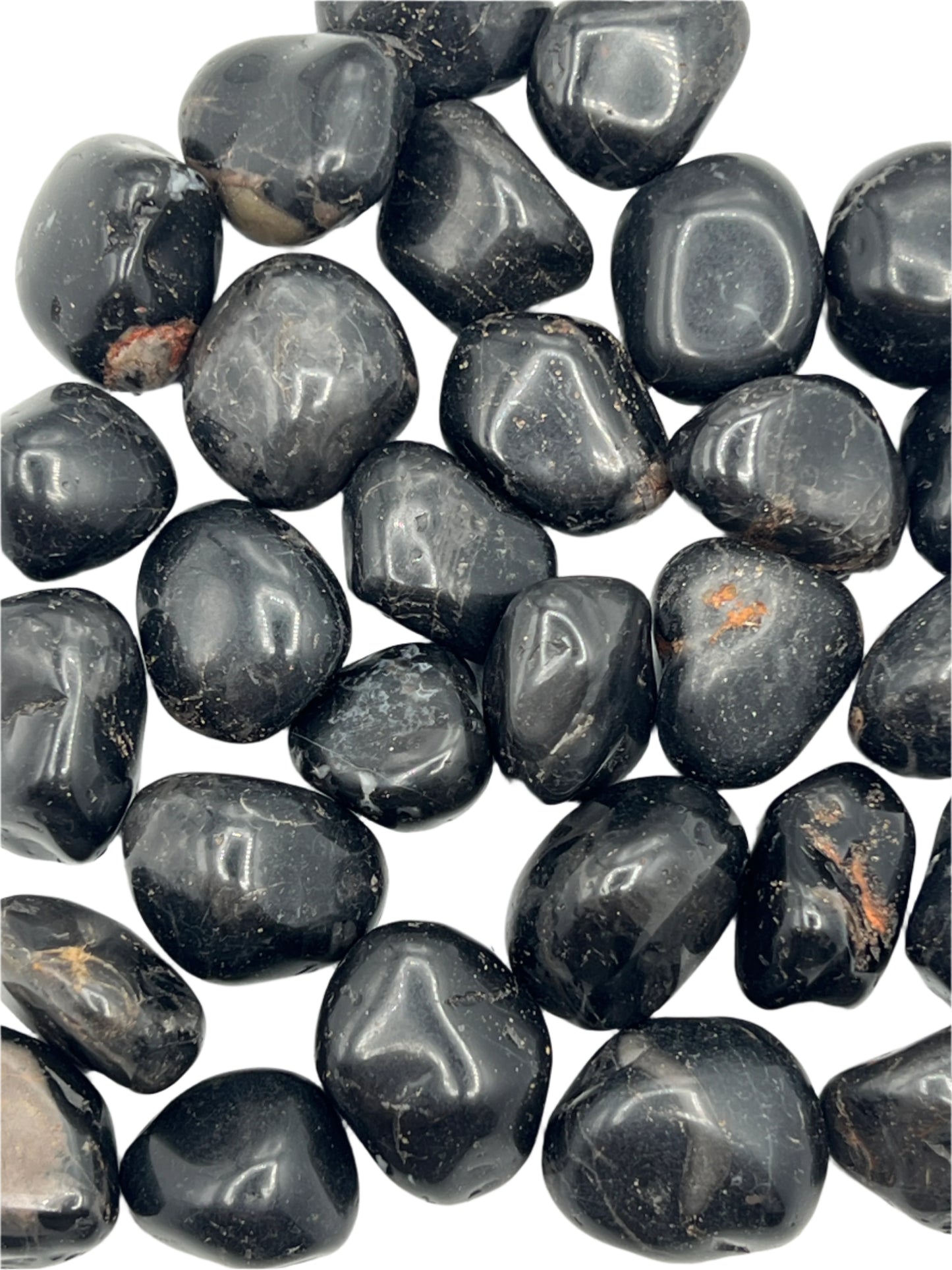 Collection of black onyx tumbled stones on a white background
