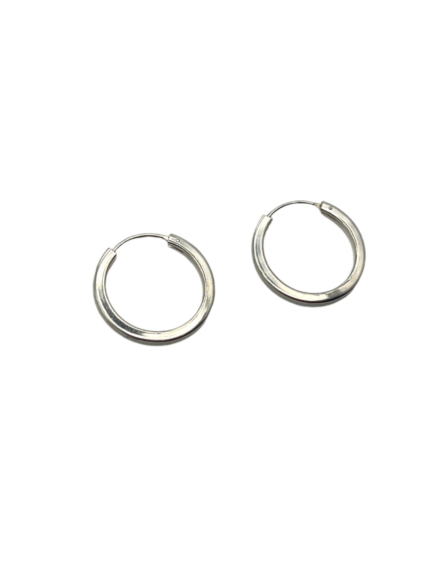 Pair of silver hoop earrings on a gray background