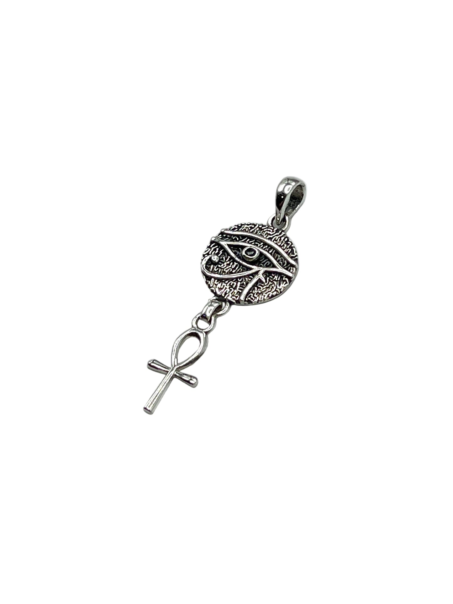 Silver pendant with decorative design and cross on a light gray background