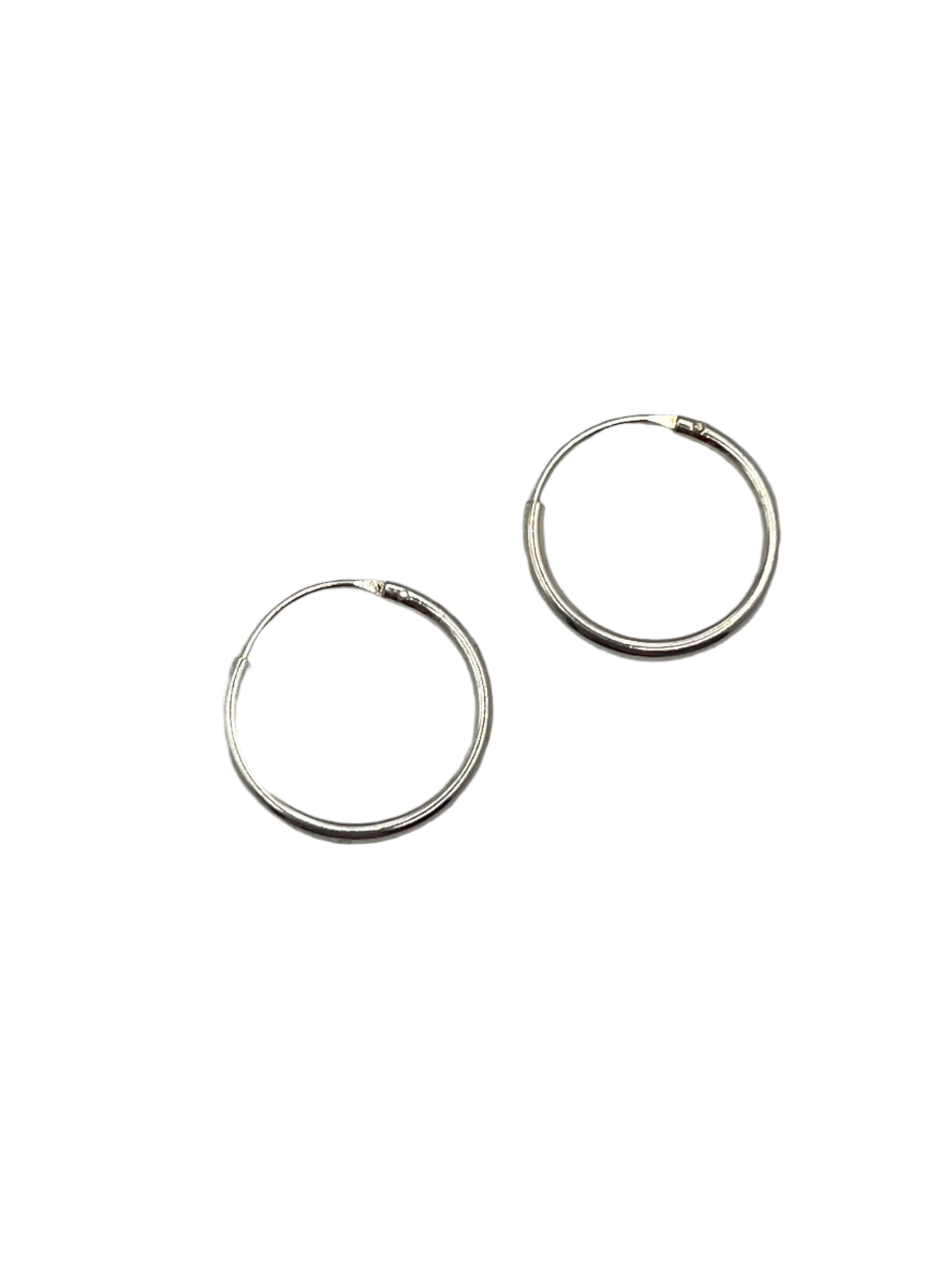 Two silver hoop earrings on a gray background