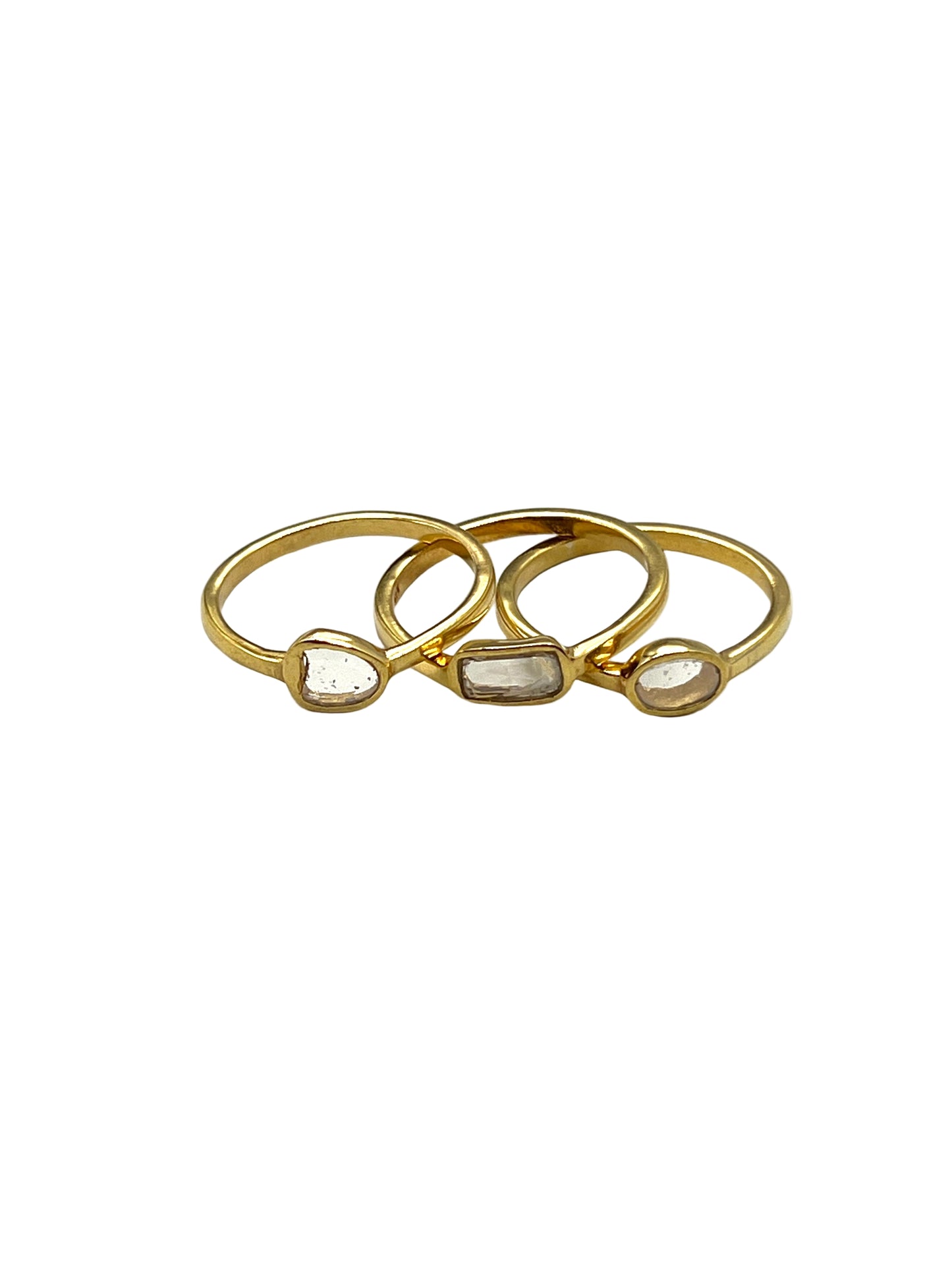 Three gold rings with embedded stones on a white background