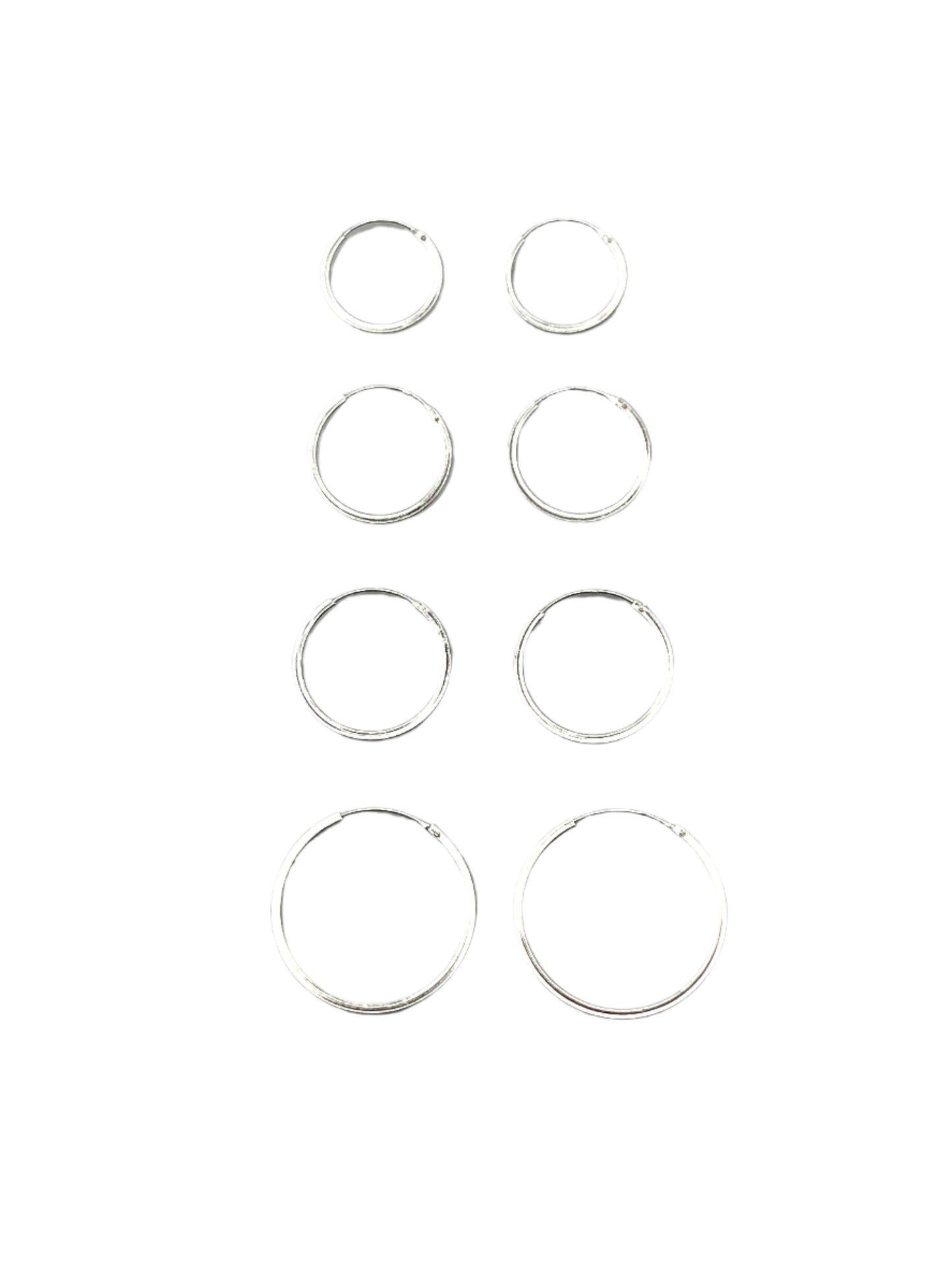 Set of silver hoop earrings on a gray background