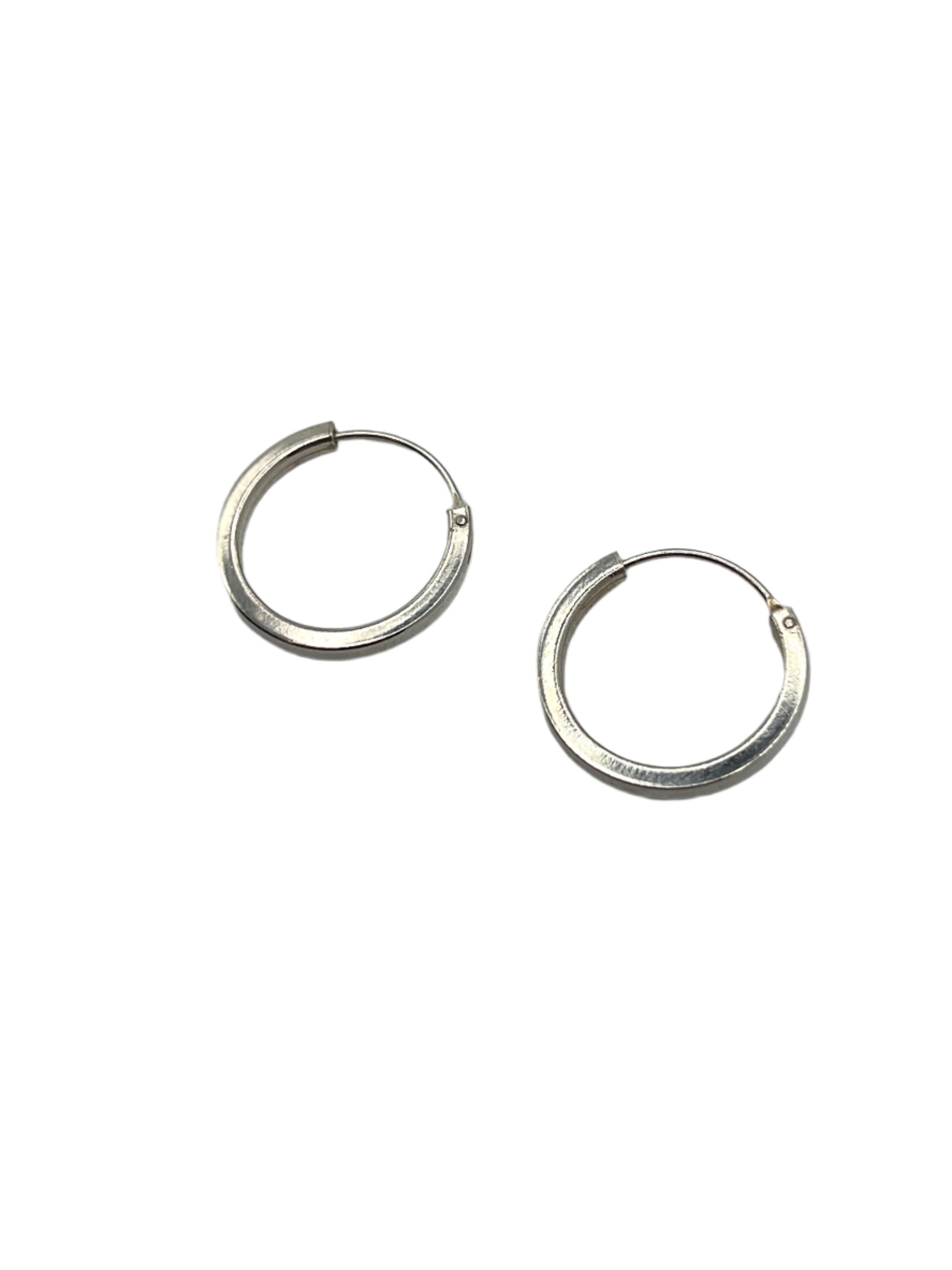 Pair of silver hoop earrings on a gray background