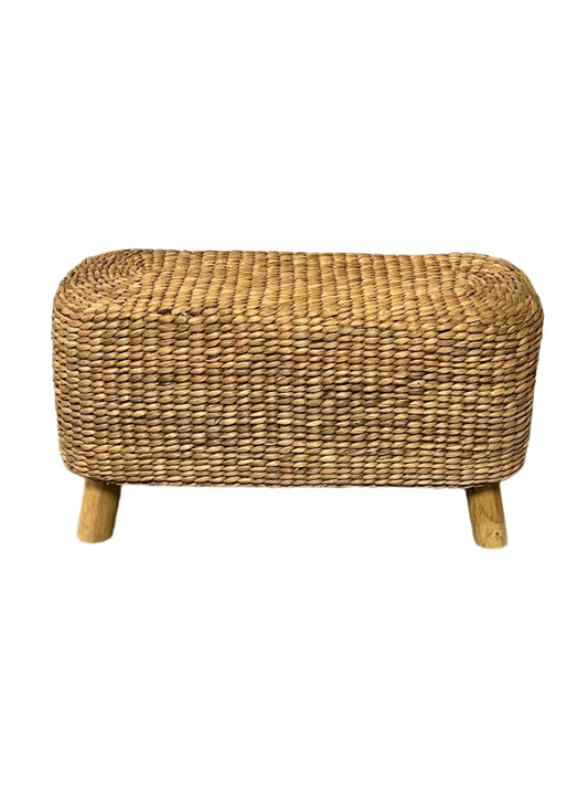 A rectangular hand made accent bench made of water hyacinth with teakwood legs.
