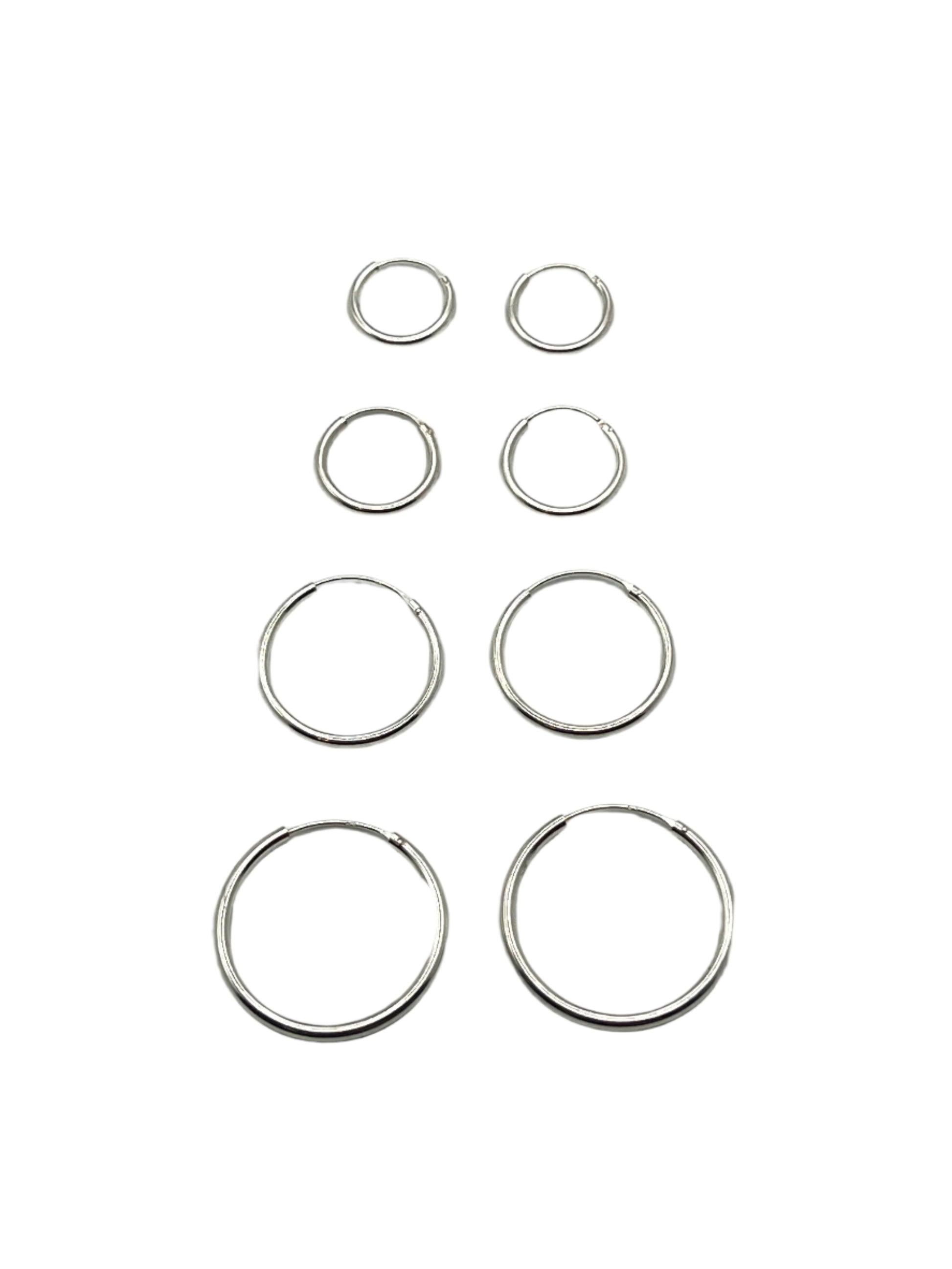Set of silver hoop earrings on a light gray background
