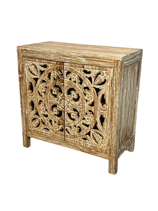 A white washed teak wood vanity with hand made mandala designs on the front, featuring two doors and a center opening.