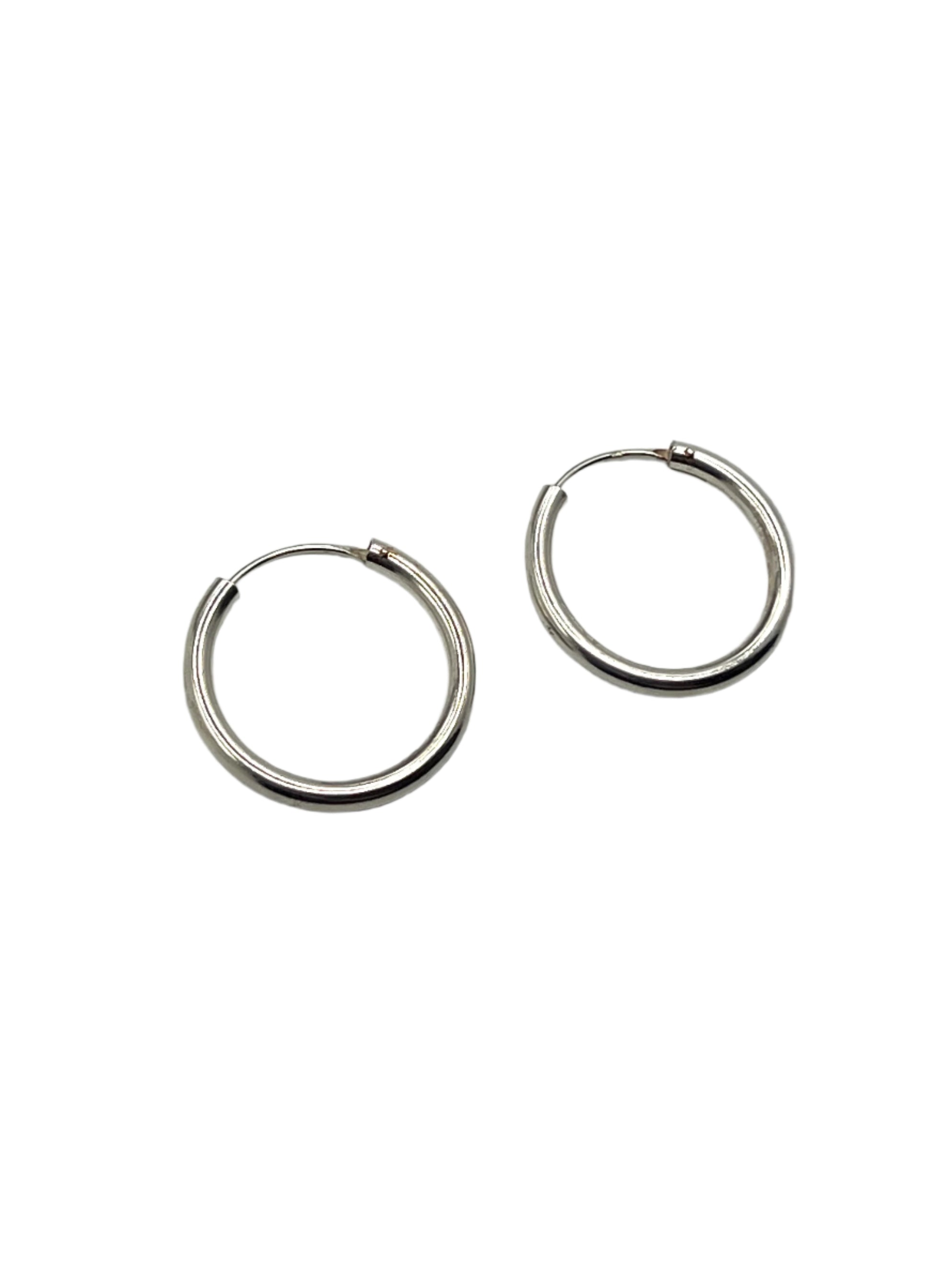 Pair of silver hoop earrings on a light gray background