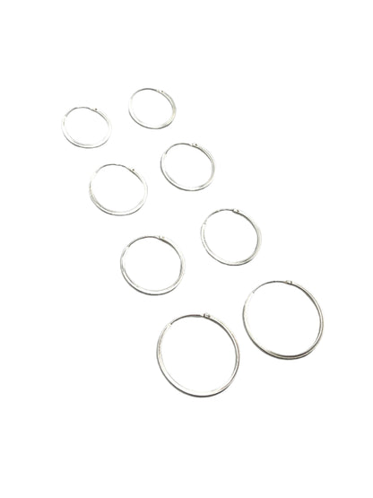 Set of silver hoop earrings on a gray background