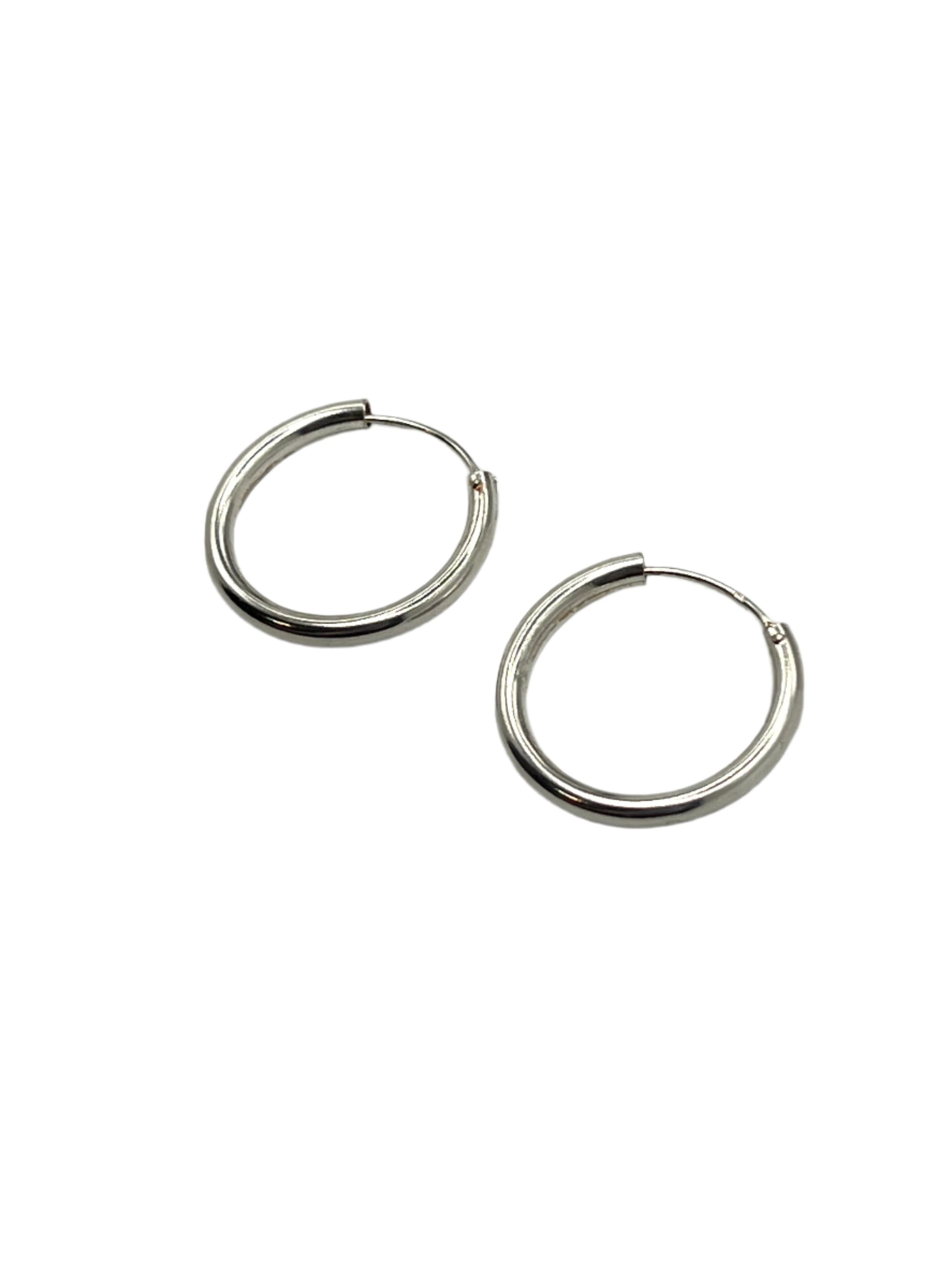 Pair of silver hoop earrings on a light gray background