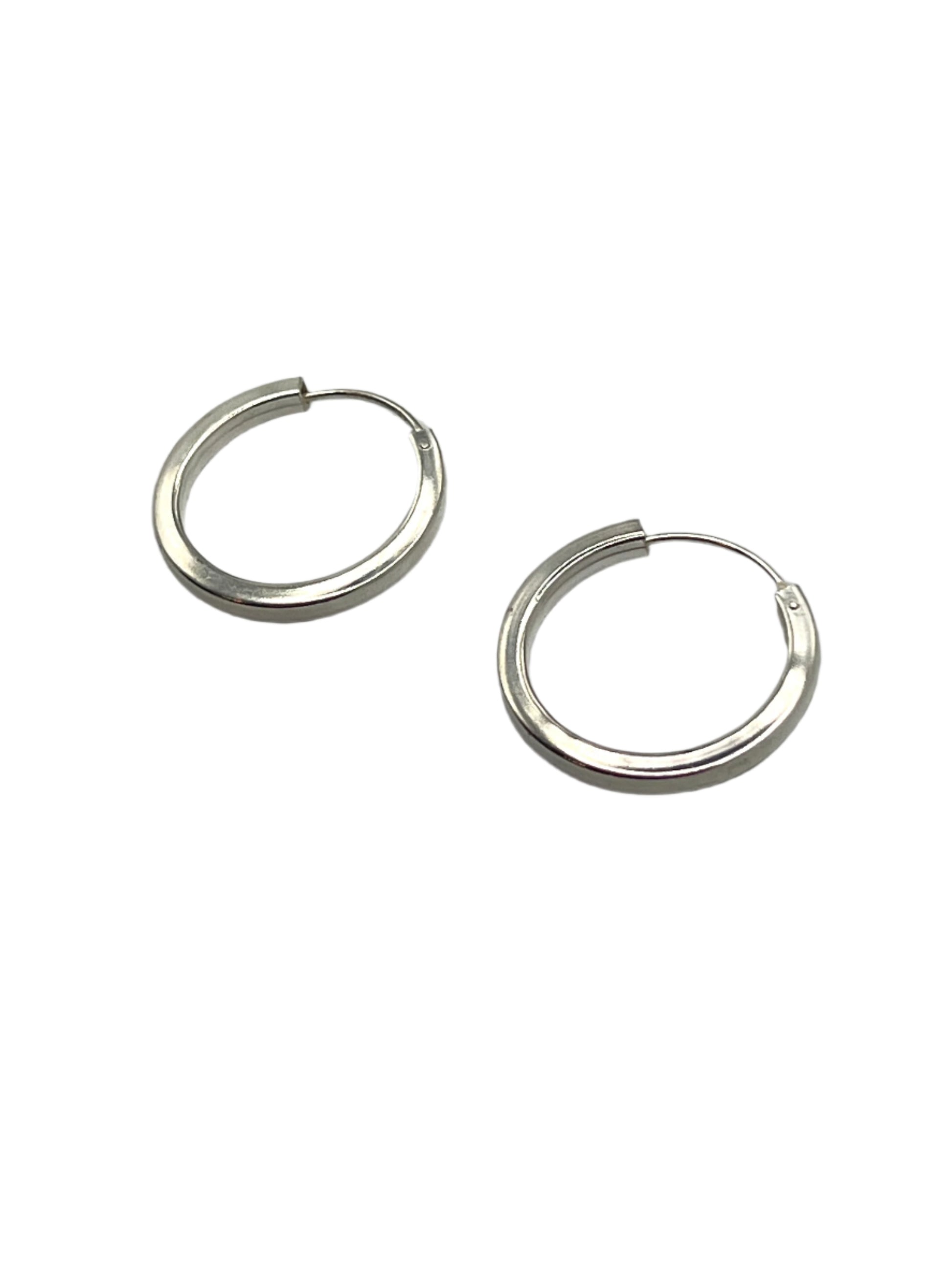 Pair of silver hoop earrings on a gray background