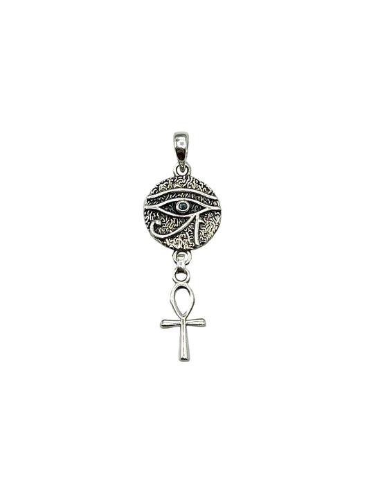 Silver pendant with eye design and ankh symbol on a light gray background