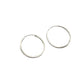 Two silver hoop earrings on a gray background