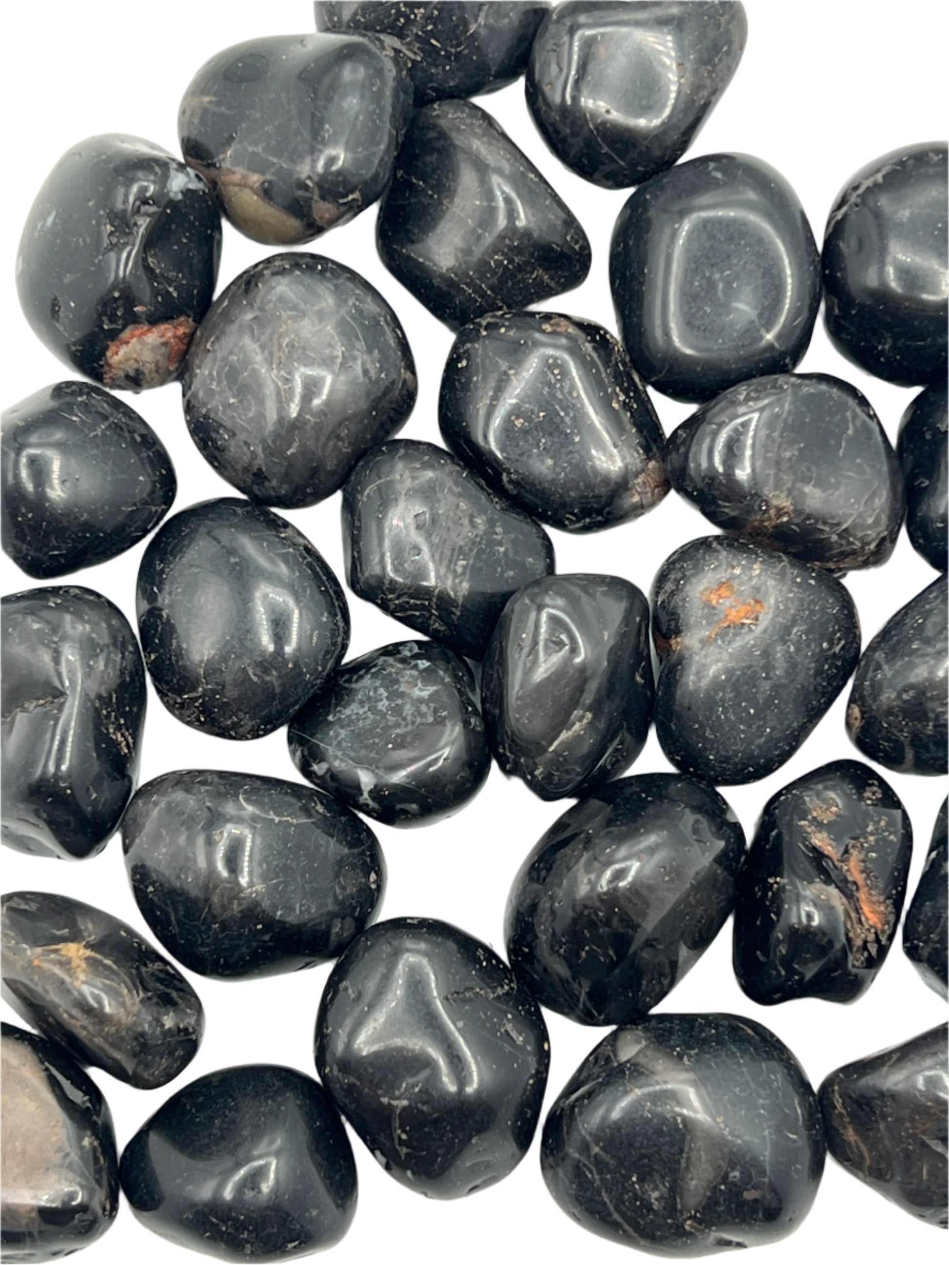 Collection of black onyx tumbled stones on a white background