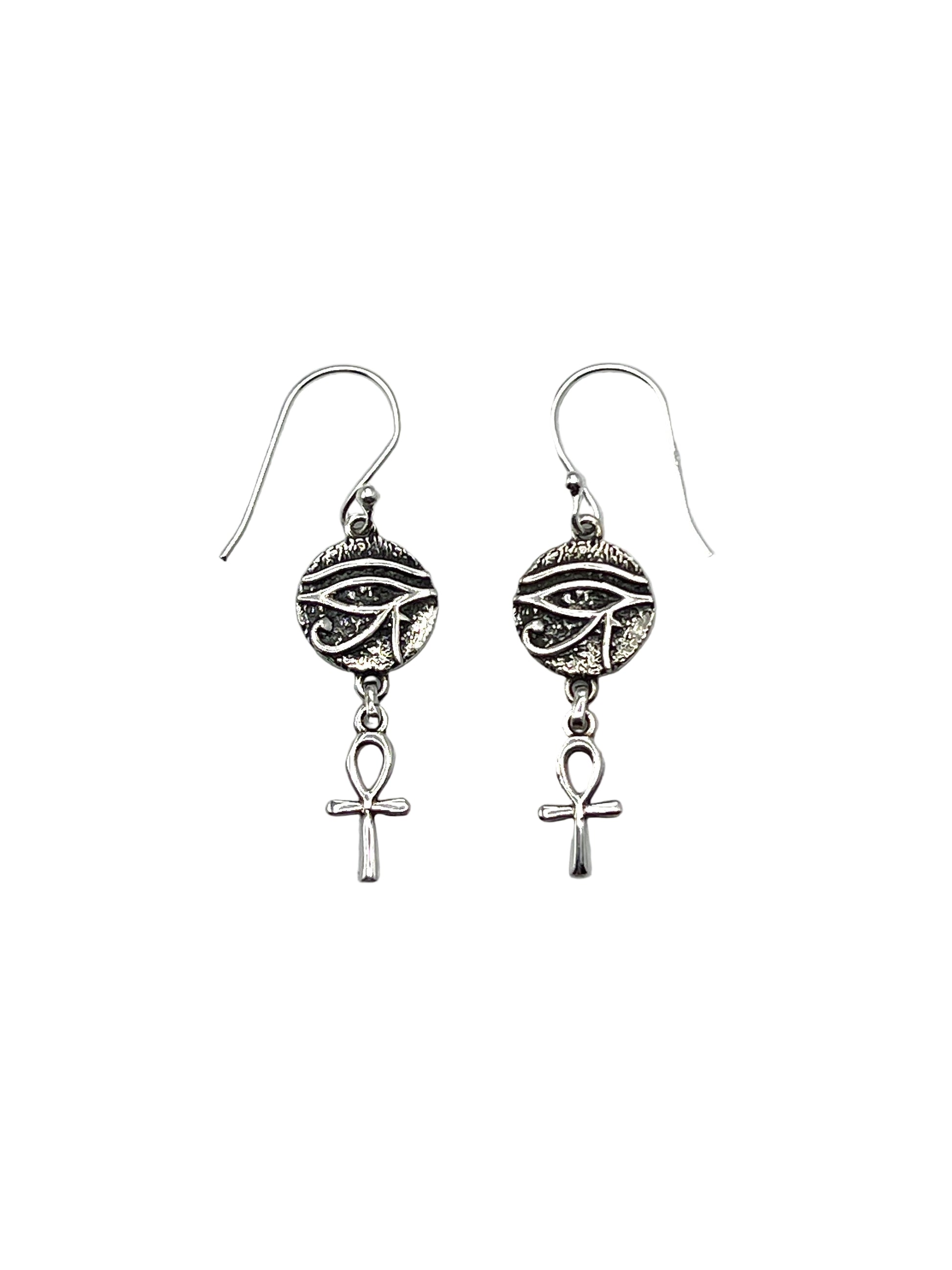 Pair of silver earrings with eye design and Ankh symbol on a light gray background