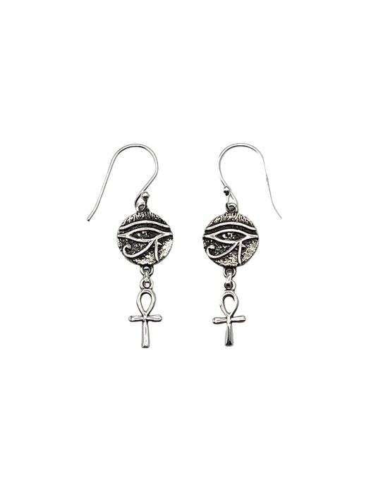 Pair of silver earrings with eye design and Ankh symbol on a light gray background