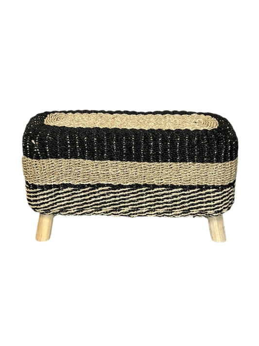 A handcrafted seagrass accent bench with black and brown stripes and wooden legs.