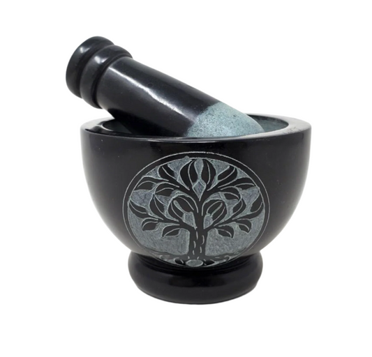 Black mortar and pestle with a tree design on a white background