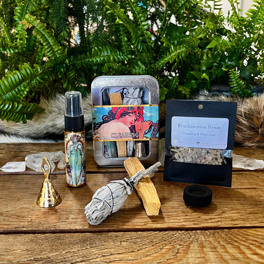 Collection of spiritual and wellness items on a wooden surface with greenery in the background.